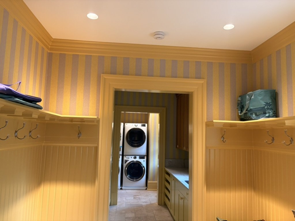 Mudroom with painted beadboard wainscoting and trim leading to the laundry room