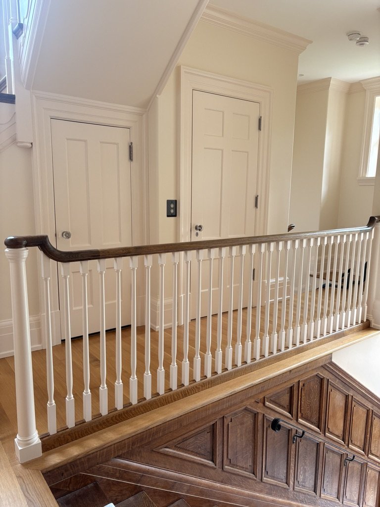 Upstairs landing with white balusters, painted doors and trim